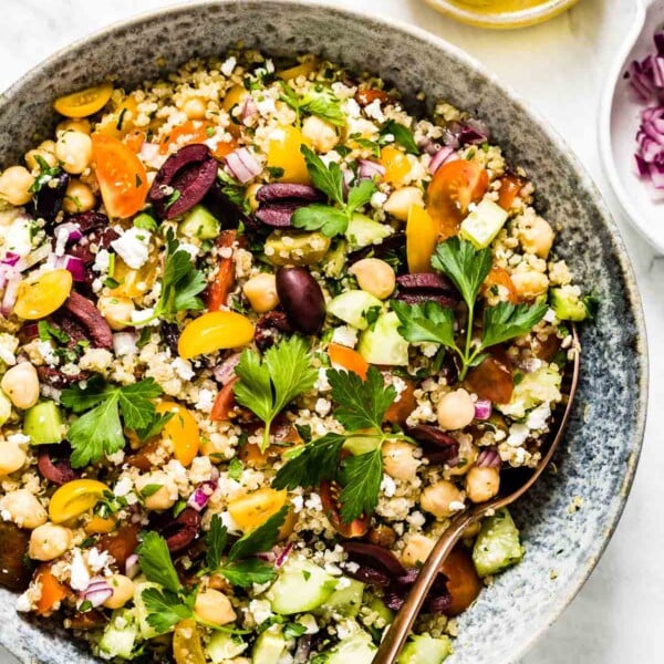 A big bowl of Mediterranean Quinoa Salad with salad dressing on the side