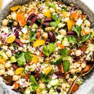 A bowl of Mediterranean Quinoa Salad with lemon vinaigrette on the side