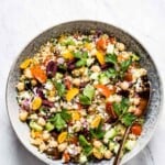 A bowl of Mediterranean quinoa salad with feta from the top view with a spoon in the bowl.
