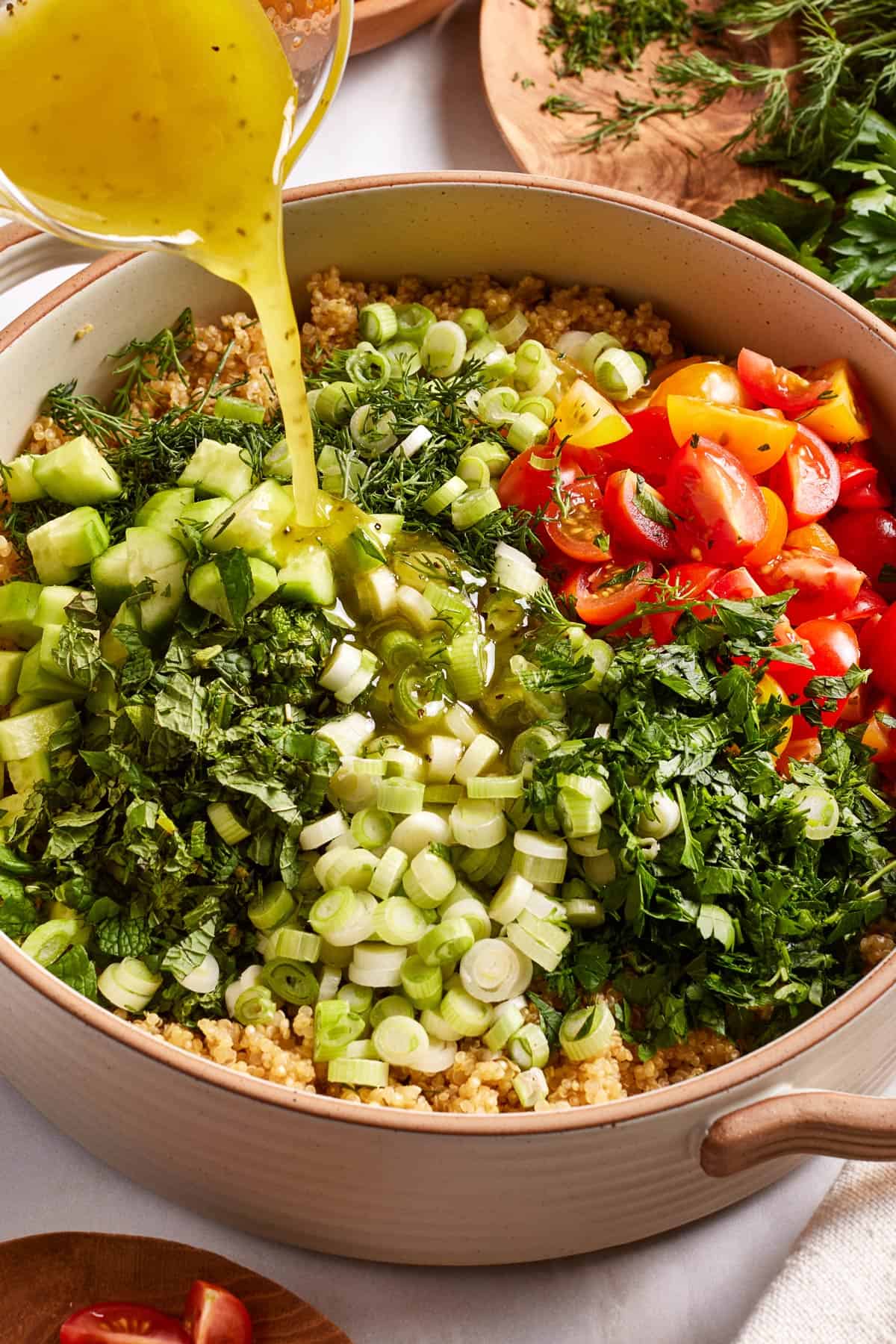 Quinoa tabouli being drizzled with the dressing.