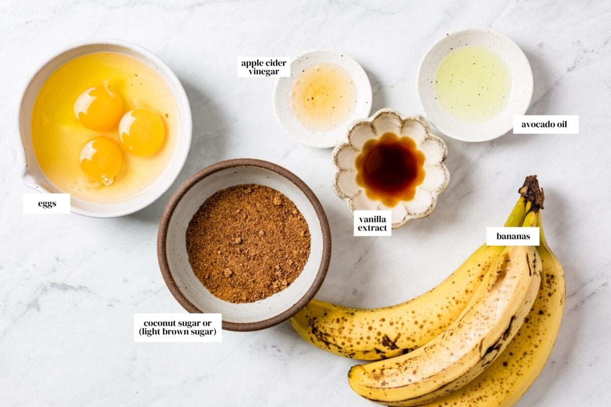 Wet ingredients in small bowls with text on each one from the top view.