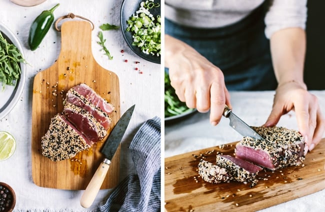 A woman is slicing sesame seared tuna to use in a green salad