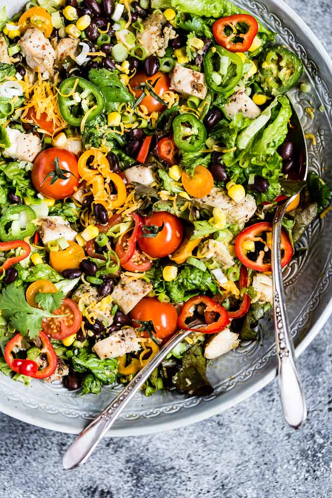 A bowl of southwest chicken salad placed in a salad bowl and photographed from the top