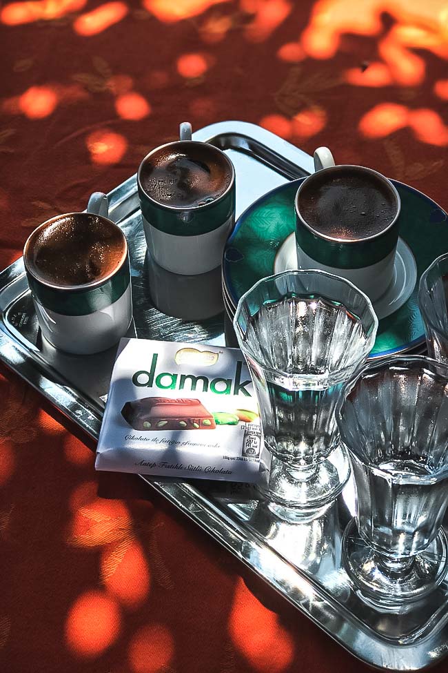 Turkish coffee and chocolate served with water on a silver tray