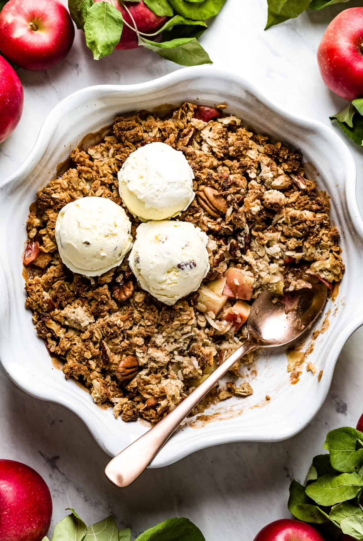 Vegan apple crisp topped off with ice cream in a pie plate	