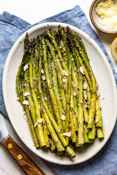 Baked Asparagus recipe placed on a plate and garnished with parmesan