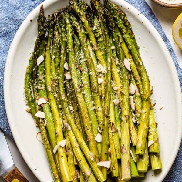 Baked Asparagus recipe placed on a plate and garnished with parmesan