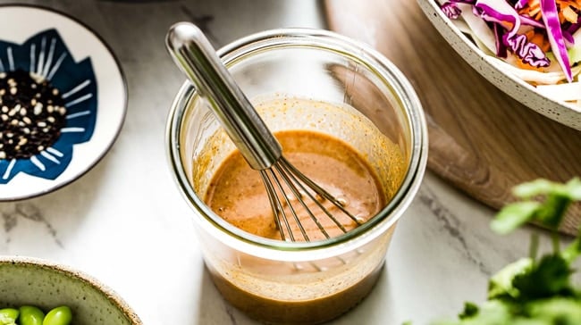 Thai-Style Peanut butter dressing with a whisk in a jar