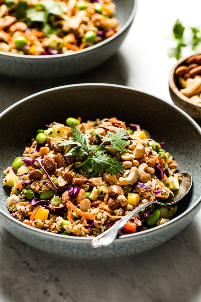 A bowl crunchy Thai quinoa salad in a bowl with a spoon on the side