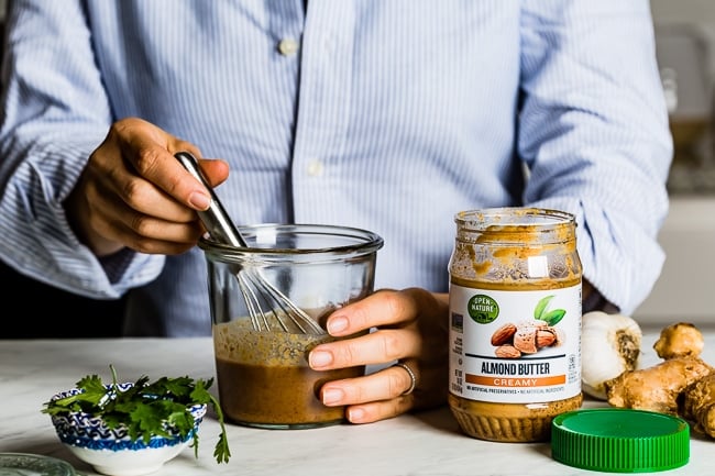 Person whisking vegan spicy peanut dressing 