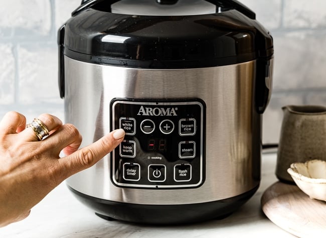 Person showing what setting to cook quinoa in an Aroma cooker