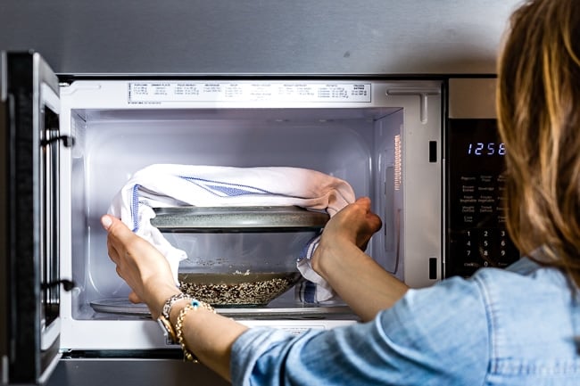 Person removing cooked quinoa from the microwave