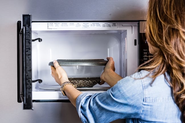 Person placing the bowl in the microwave