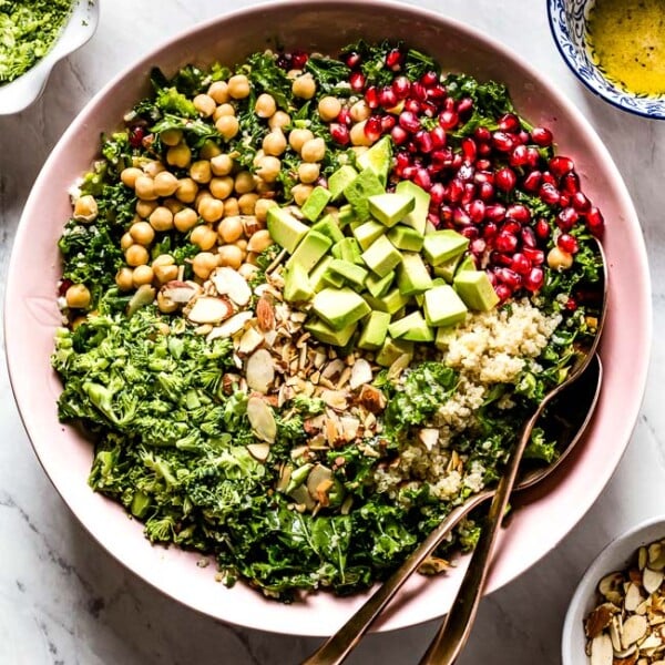 Kale Quinoa Salad in a bowl with spoons on the side