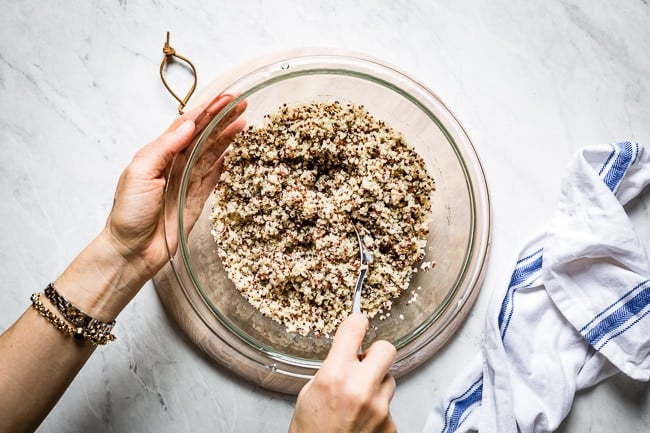 Person fluffing microwave quinoa with a fork