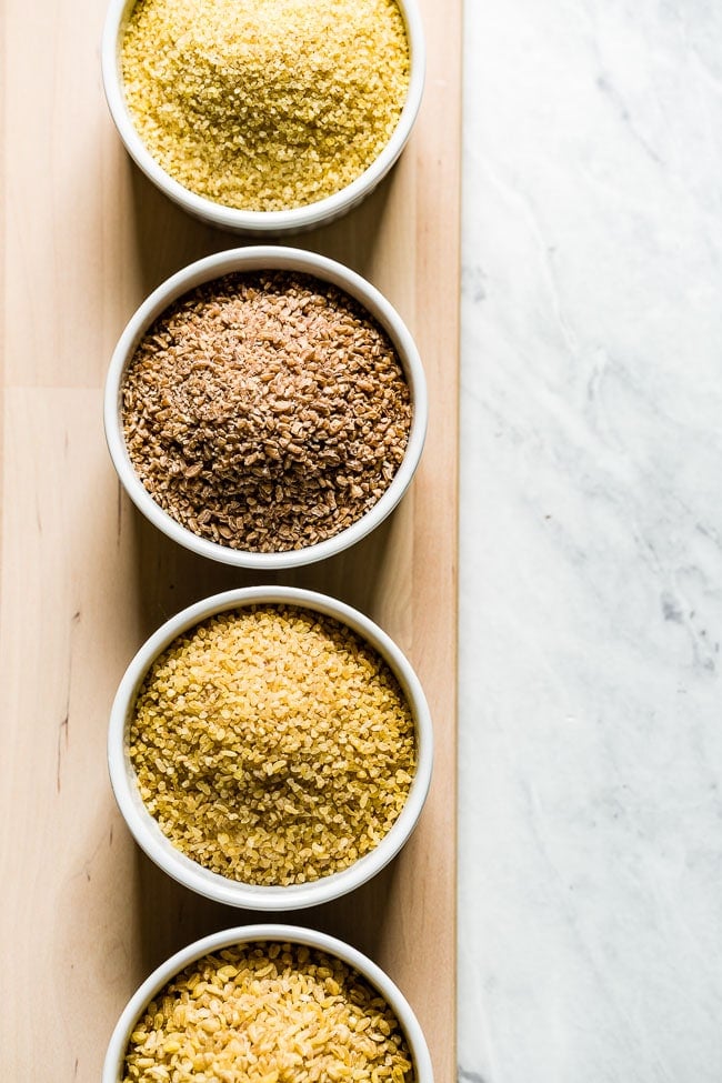 Different sizes of bulgar wheat placed in four bowls from the top view