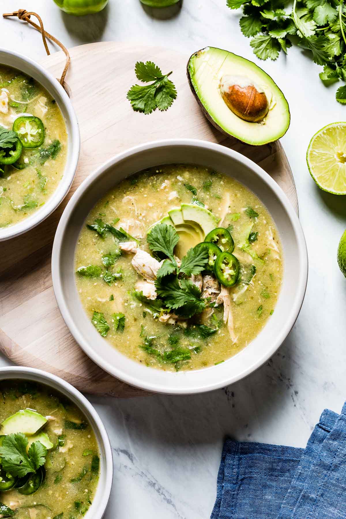 Slow Cooker Chicken tomatillo stew garnished with avocados, cilantro and jalapenos