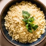 Cooked bulgur wheat placed in a bowl with a spoon on the side