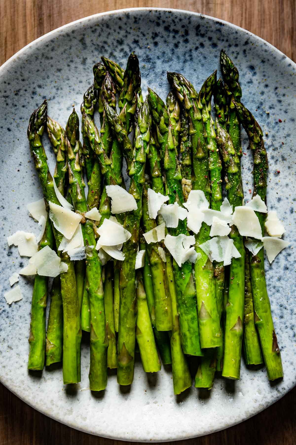 Sauteed Asparagus topped off with parmesan cheese on a plate