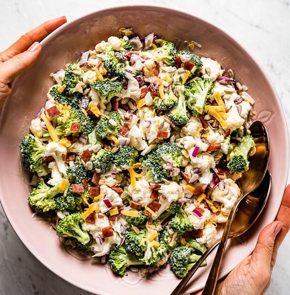 Broccoli Cauliflower Salad recipe served in a bowl by a person