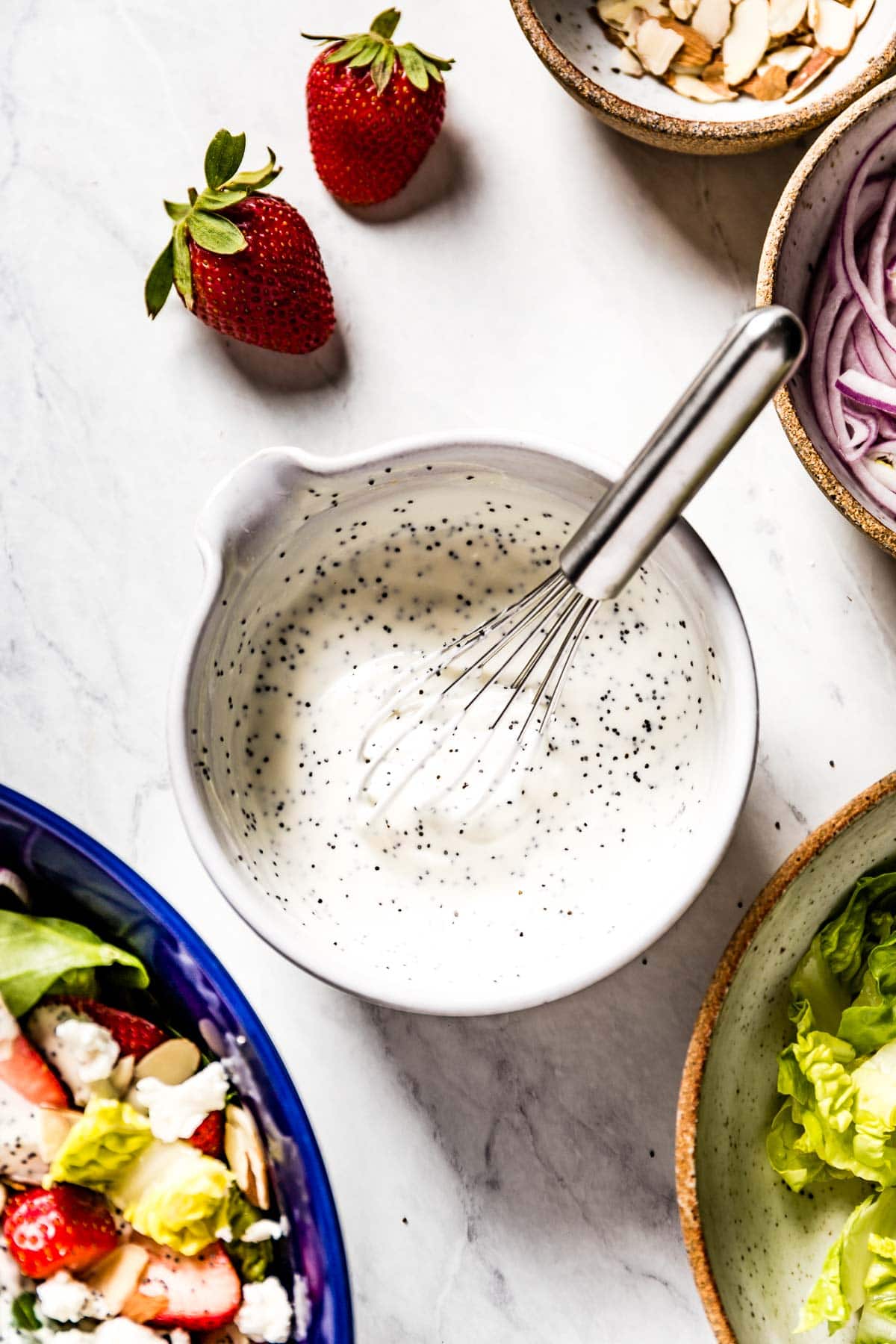 Creamy Poppy Seed Dressing placed in a bowl with a whisk