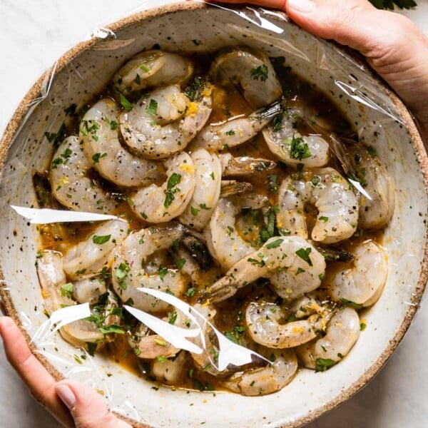 Shrimp Marinade and shrimp in a bowl covered with plastic wrpa