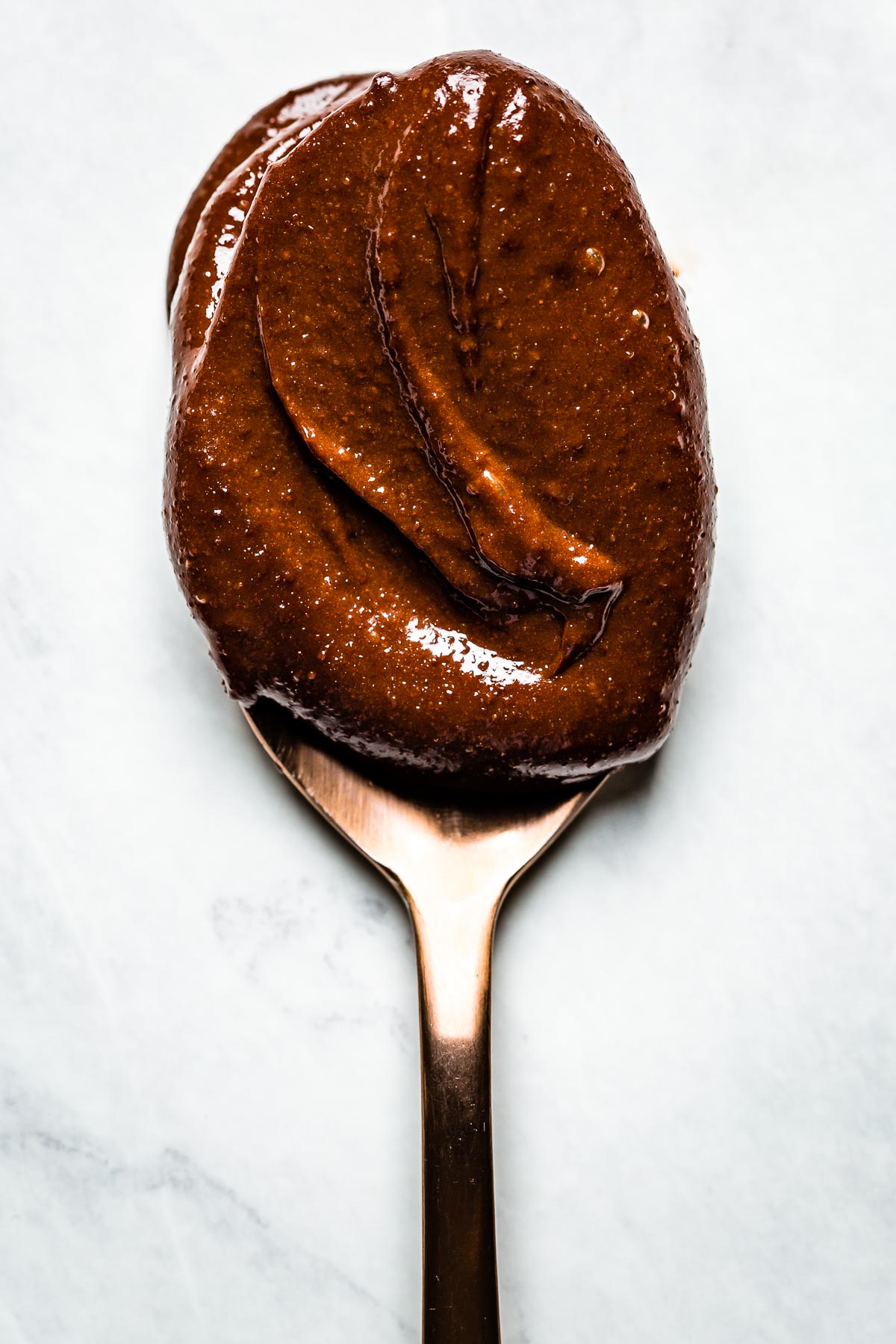 Healthy chocolate frosting spread on a spoon