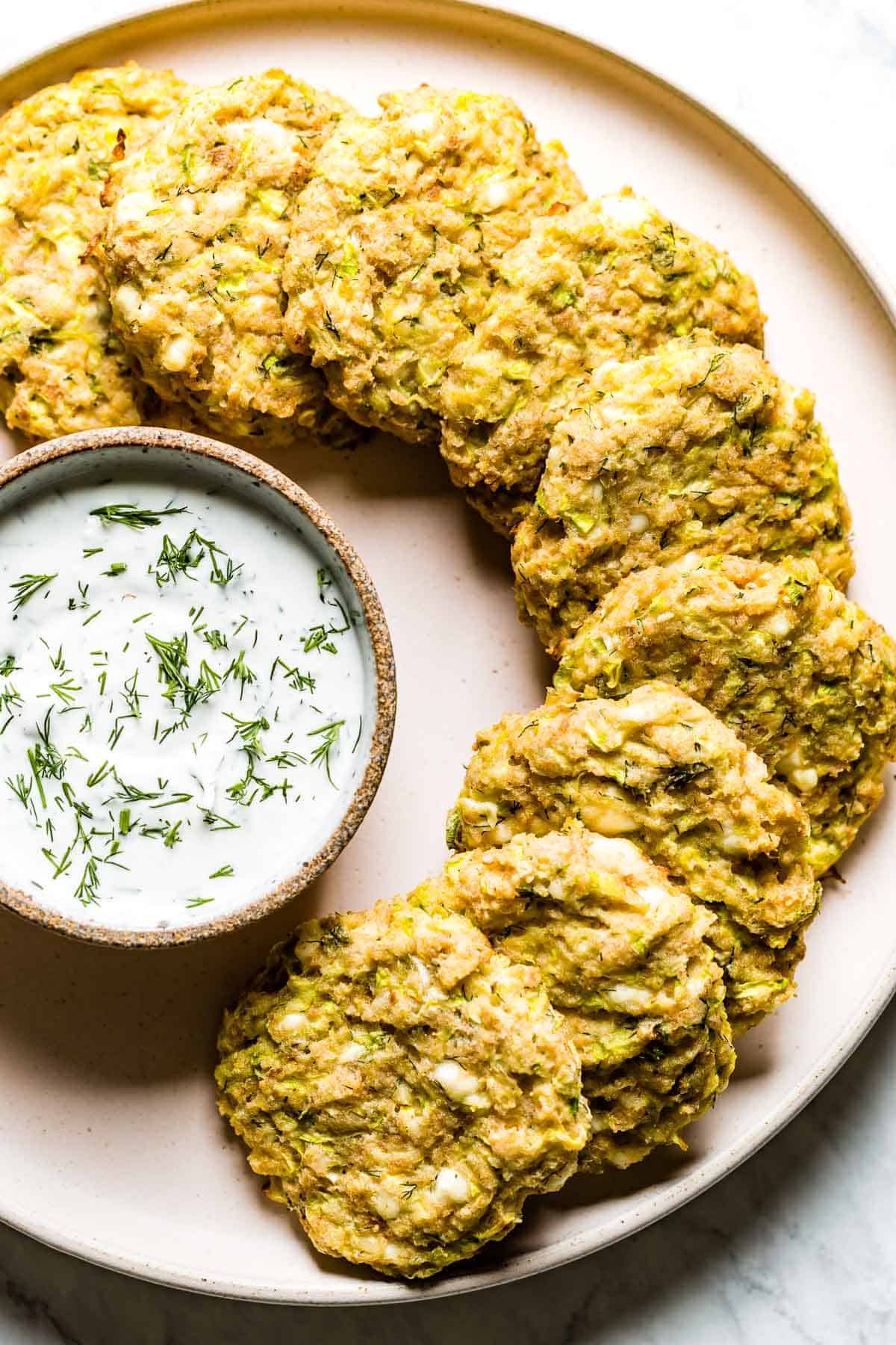 Baked Courgette Fritters on a plate served with yogurt sauce