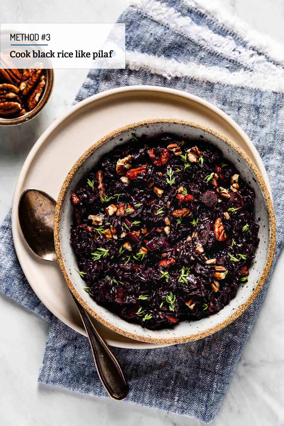 Black Rice pilaf in a bowl with a spoon on the side