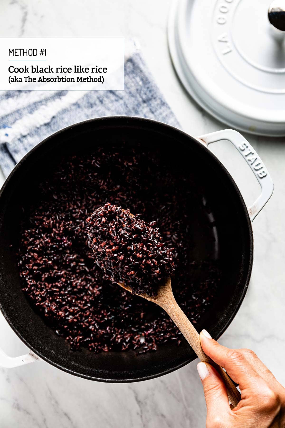 Person showing cooked black rice using the absorption method