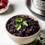 cooked black rice in a bowl in front of an instant pot