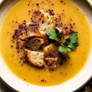 A bowl of soup topped with croutons