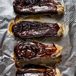 Whole roasted Eggplant on a sheet pan right after it comes out of the oven