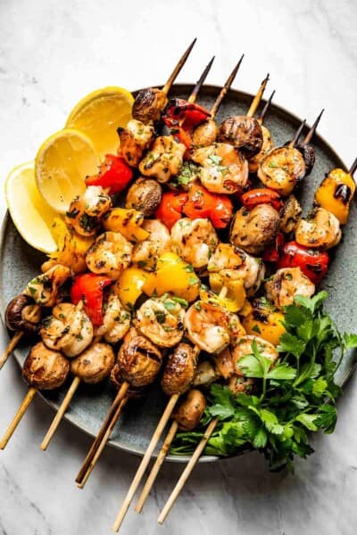 Grilled Shrimp Kabobs with Vegetables on a plate with wedges of lemon