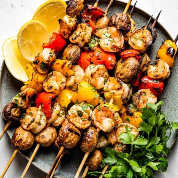 Grilled Shrimp Kabobs with Vegetables on a plate with wedges of lemon