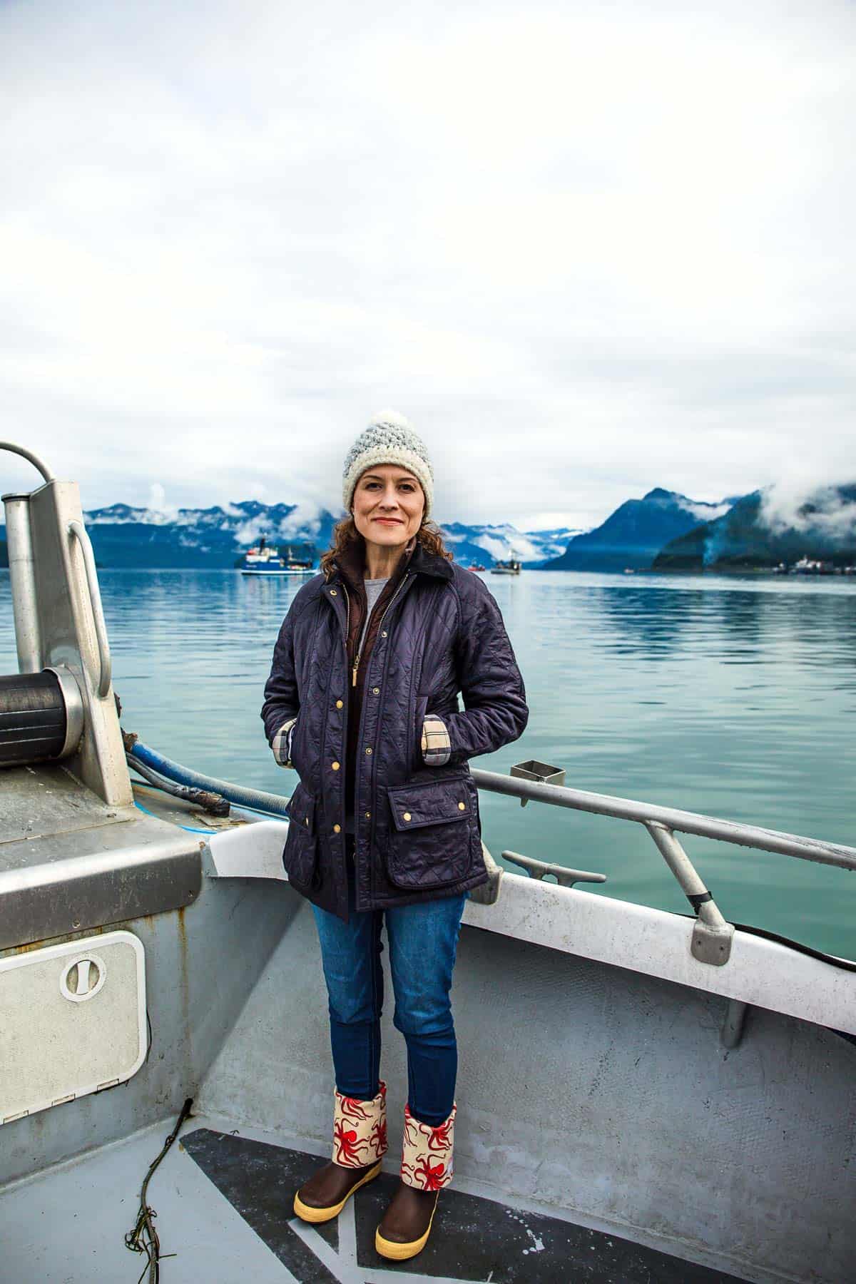 Aysegul Sanford on a boat in Alaska with mountains in the background
