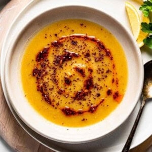 Turkish red lentil soup drizzled with chili oil in a bowl from the top view.