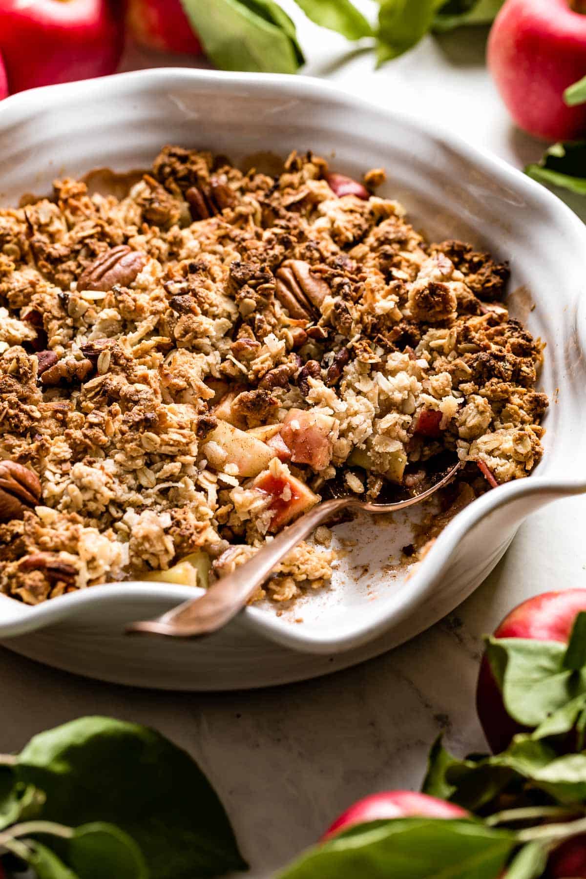Vegan apple crisp with a spoon in the dish.