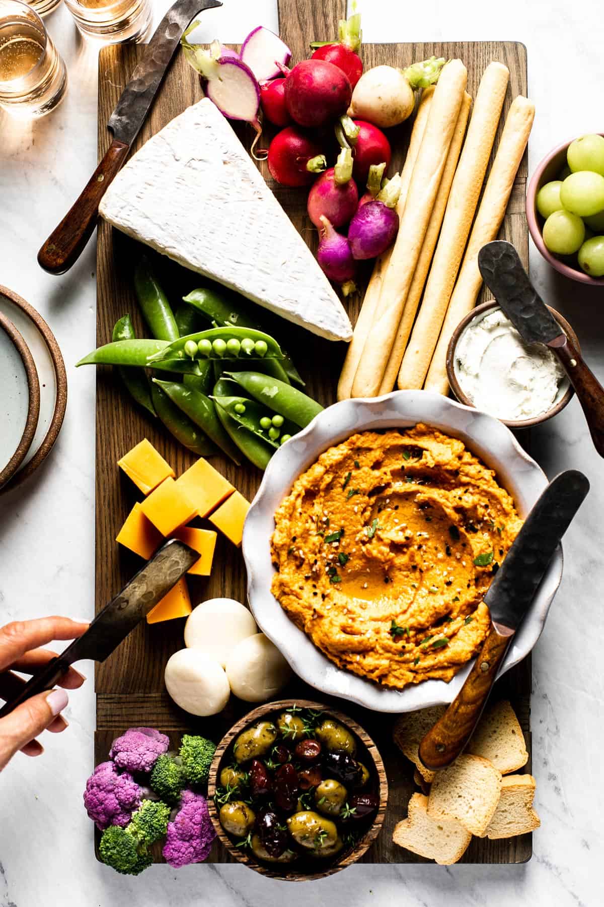 Carrot hummus is being served as a part of cheese platter