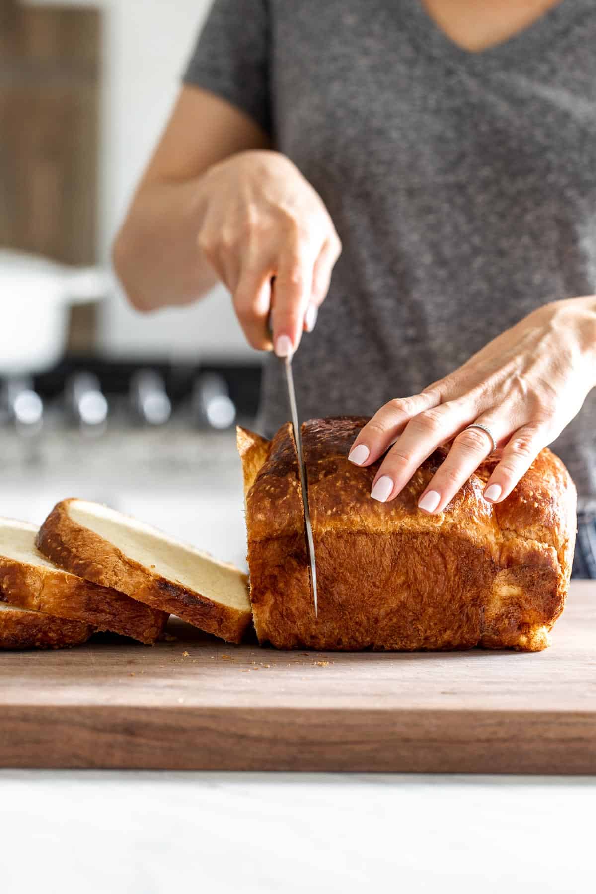 Person slicing brioche bread from the front view