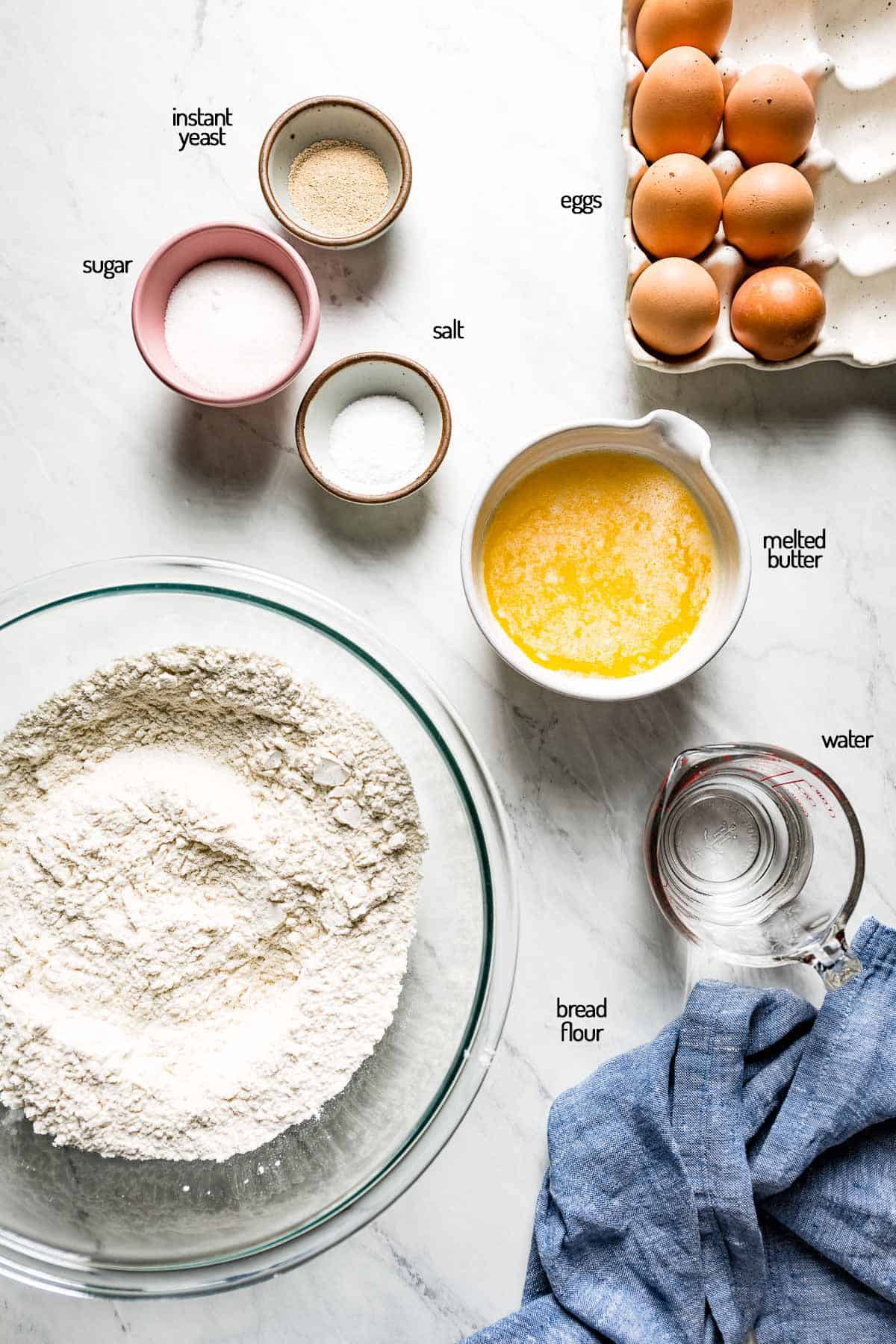 ingredients in brioche bread are laid out on a marble backdrop