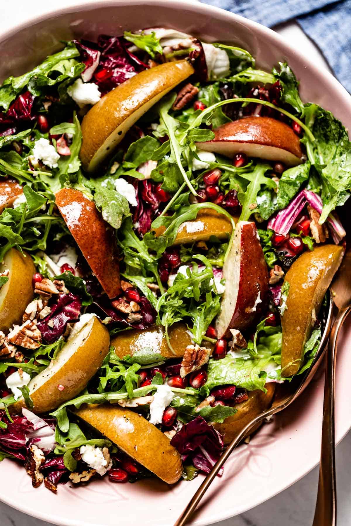 roasted pear salad in a bowl with a few spoons on the side