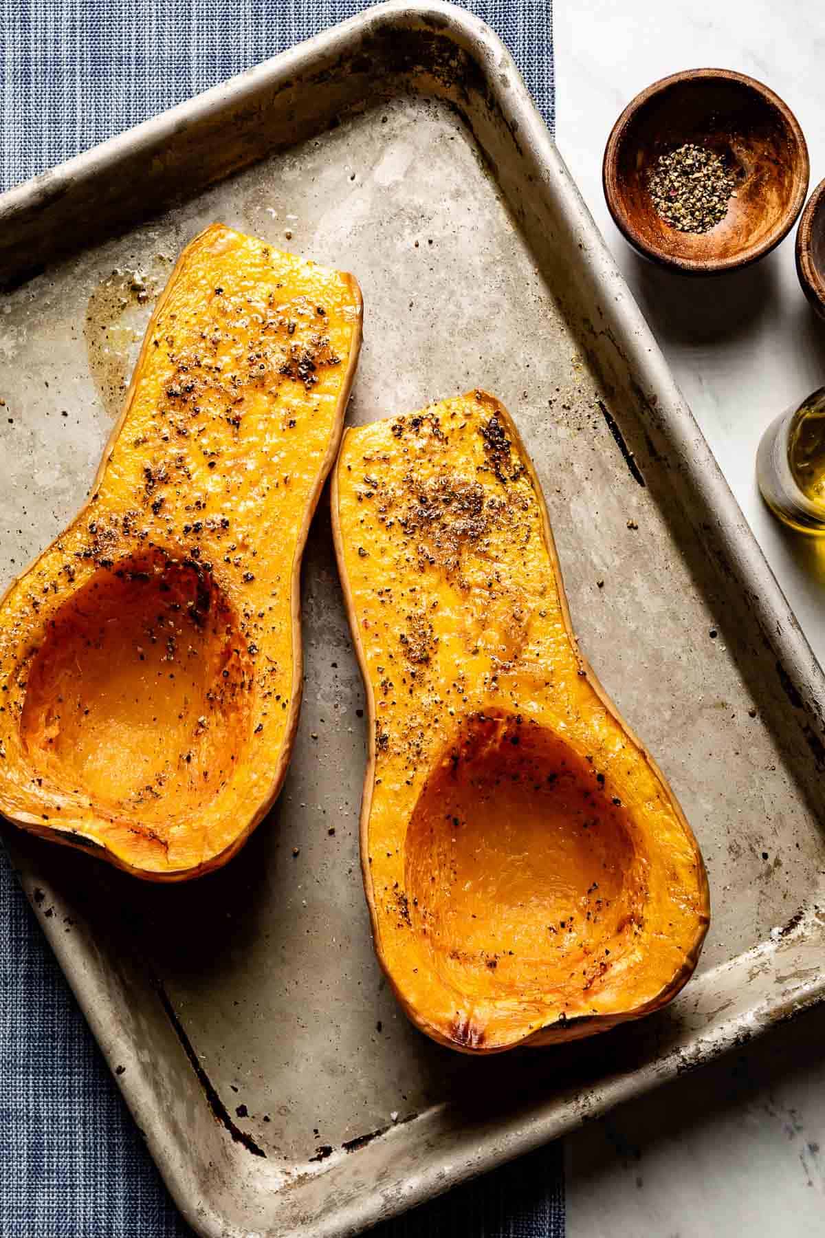 Roasted halved butternut squash on a sheet pan