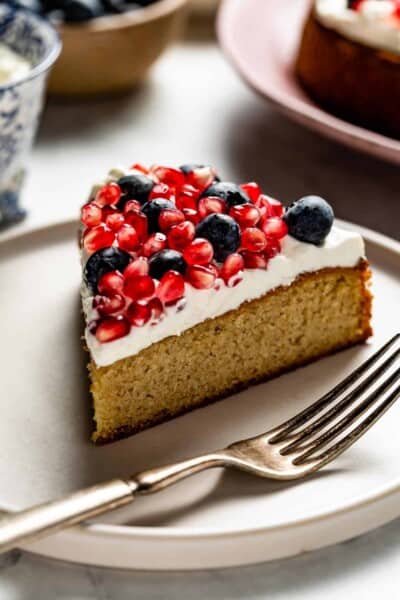 Almond Flour Cake sliced and topped off with whipped cream and fruit