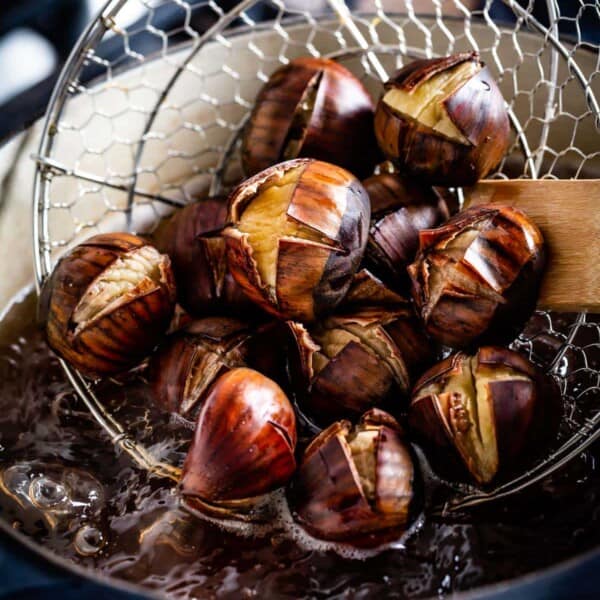 Boiled chestnuts are taken out of boiling water close up