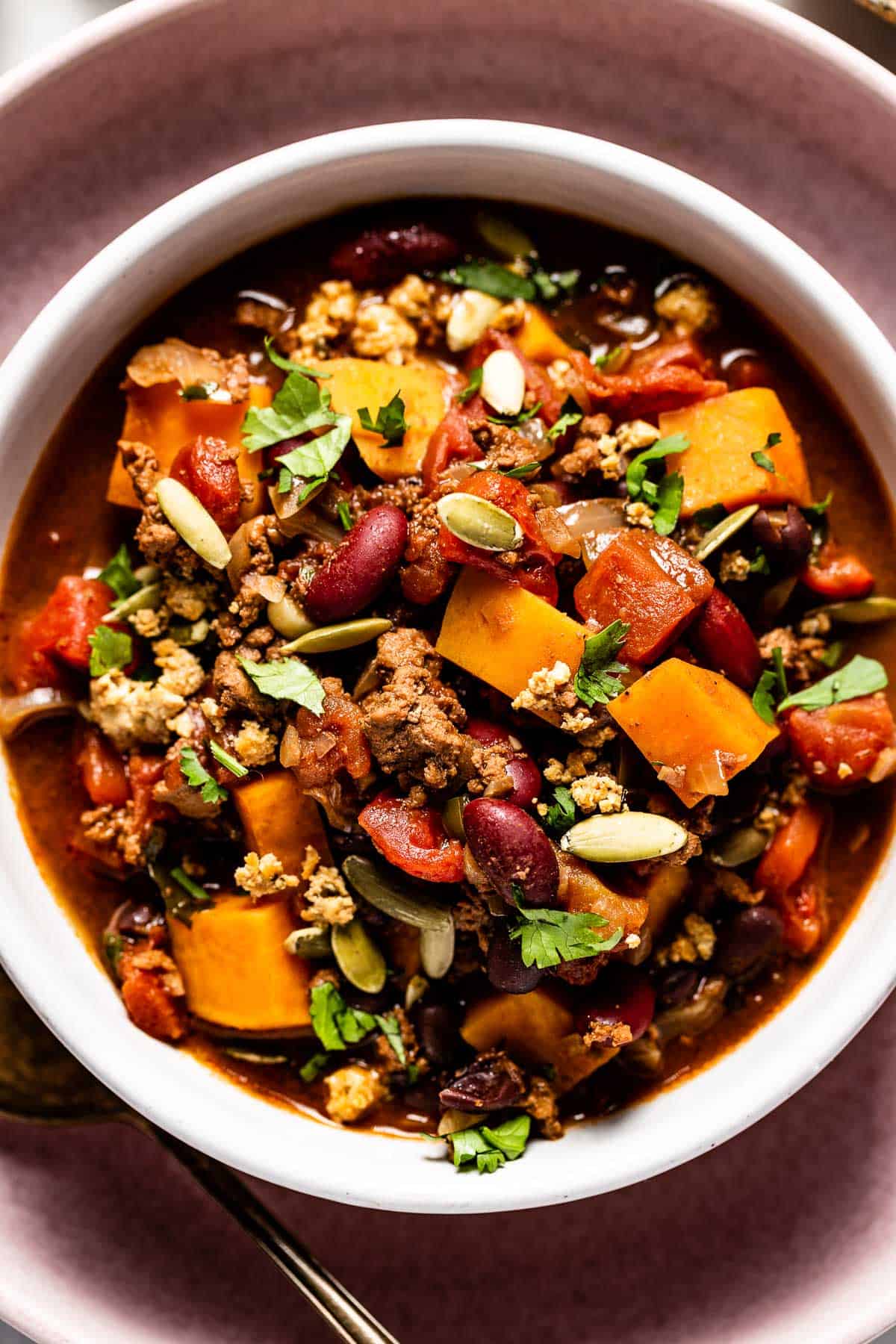 Chocolate chili with turkey in a bowl sprinkled with pumpkin seeds