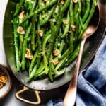Garlic Butter Green Beans in an oval dish with spoon on the side