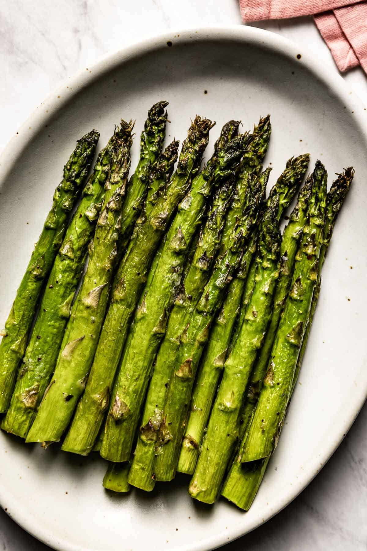 Air fried asparagus on a plate from the top view
