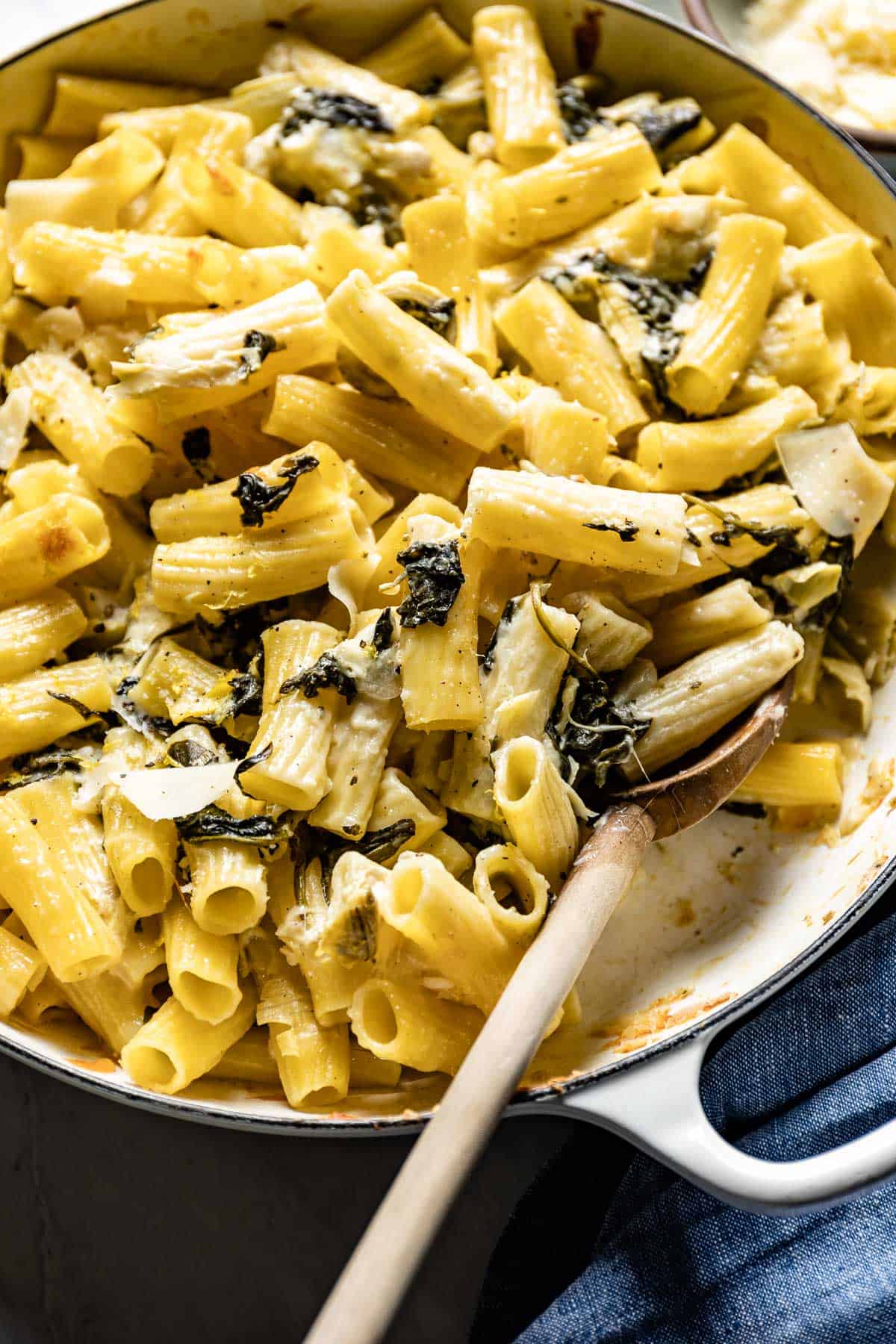 Spinach and Artichoke Pasta Bake with a wooden spoon on the side
