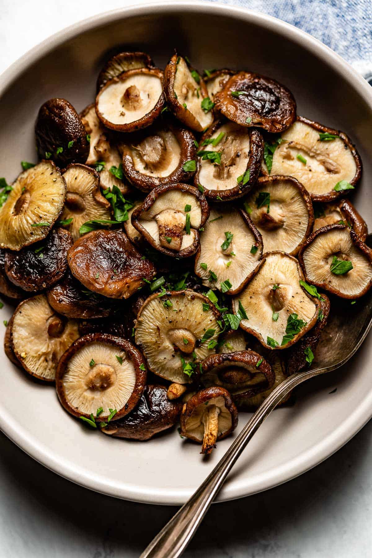 Baked Shiitake mushrooms in a plate with a spoon on the side